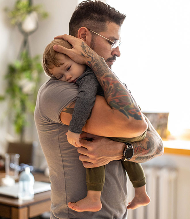 White man comforting sick toddler 